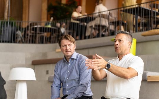 Josef Wold lyssnar på Marcelo Cáceres Longé som pratar och gestikulerar.